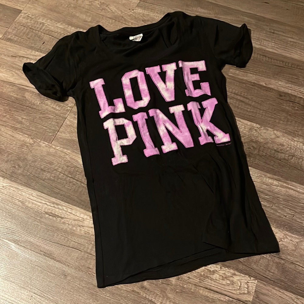 Like-new, black tee with pinkish-purple tie-dye lettering. Size XS